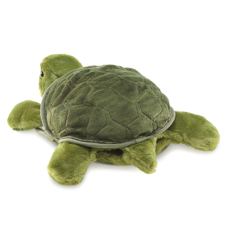Ein Plüschtier-Schildkröte mit grünem Samtpanzer und flauschigen Gliedmaßen auf weißem Hintergrund.