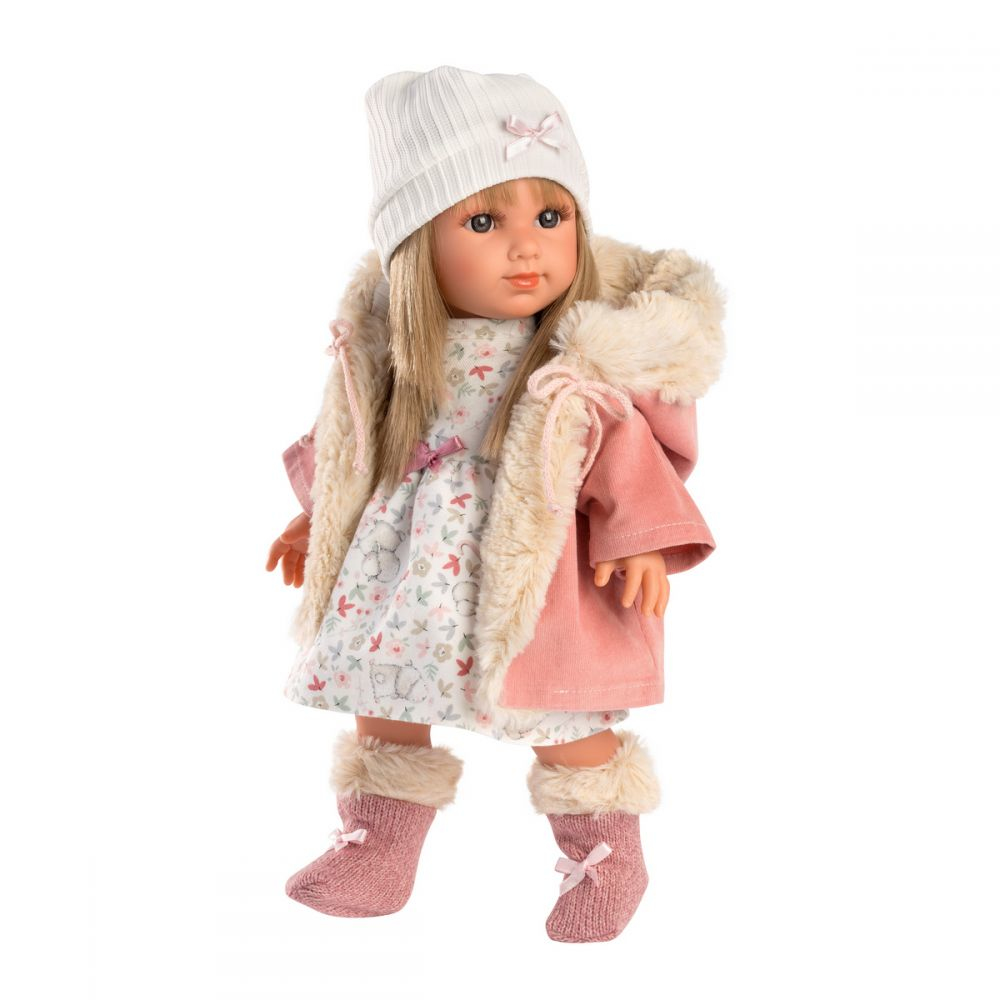 Eine süße Puppe mit rosa Mantel, Fellkapuze, Blumenkleid, weißer Mütze und rosa Puschen.