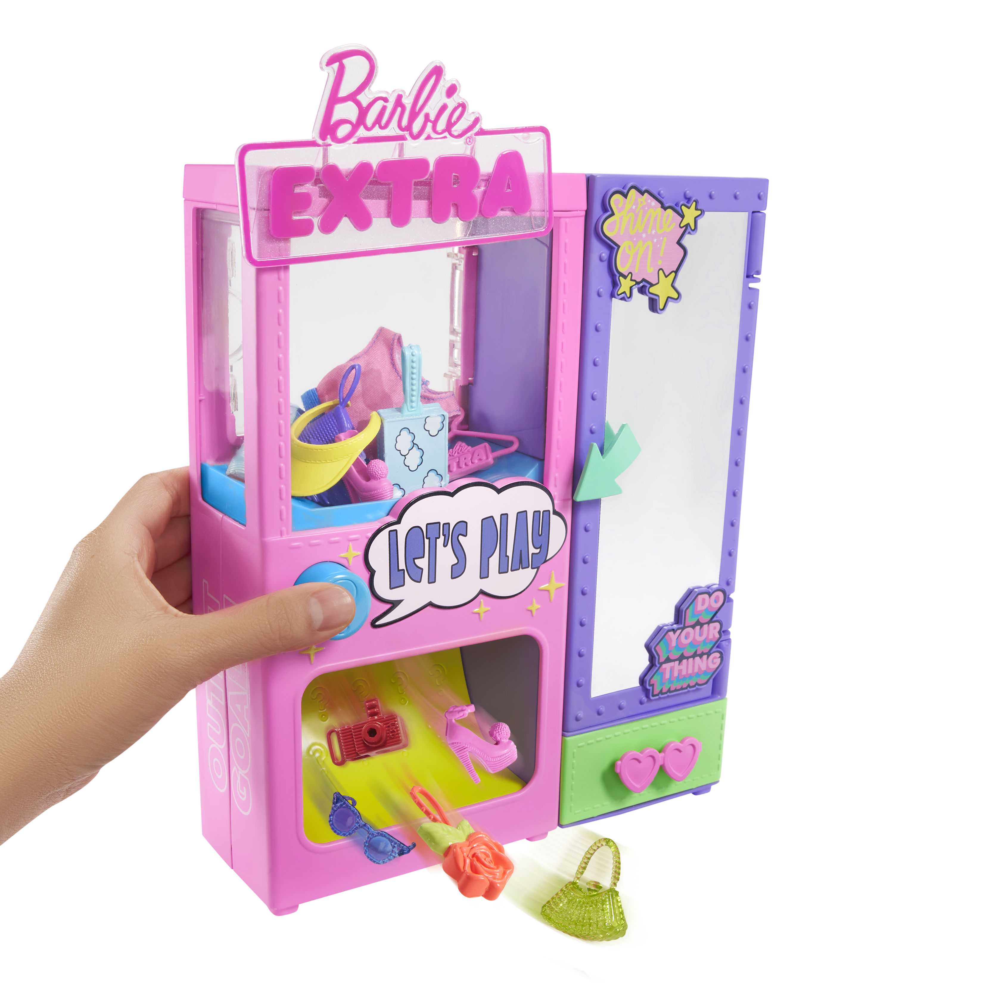 Eine Hand öffnet einen rosa und lila Barbie Extra Spielzeugschrank, der Modeaccessoires wie Schuhe, Brillen und eine Tasche ausgibt.