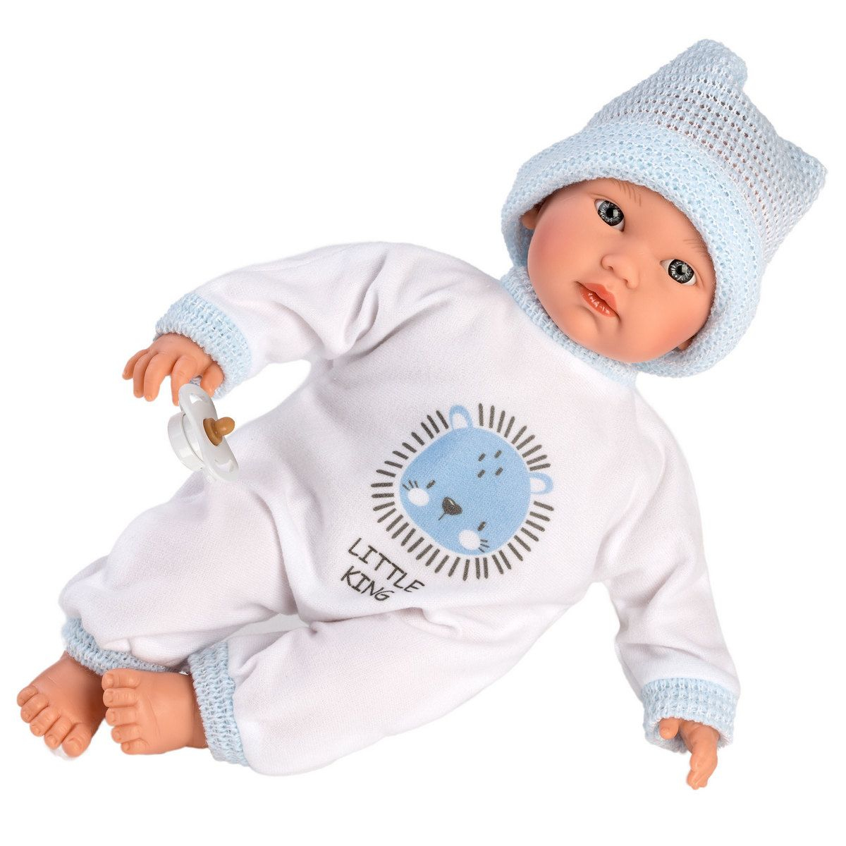 Una bambola da neonato in abiti bianchi con motivo di leone blu, cappello abbinato e ciuccio su sfondo bianco.