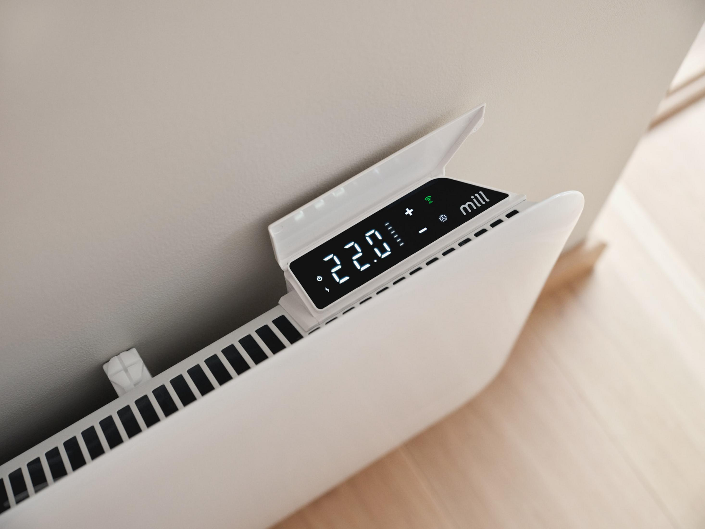 Un termosifone Mill bianco a parete mostra un display digitale con 22,0 gradi.