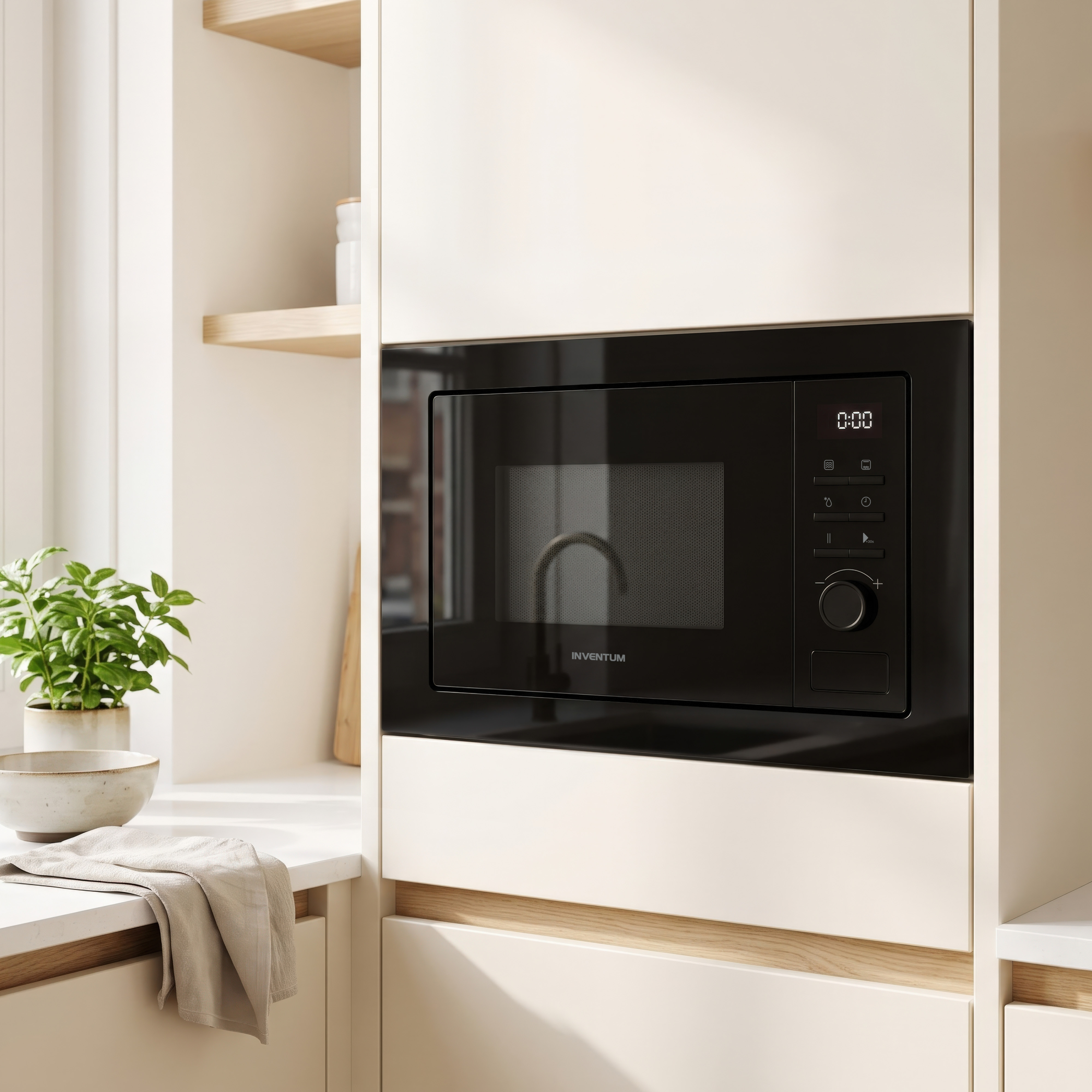 Micro-ondes noir encastré dans une cuisine moderne et lumineuse avec une plante sur le plan de travail.