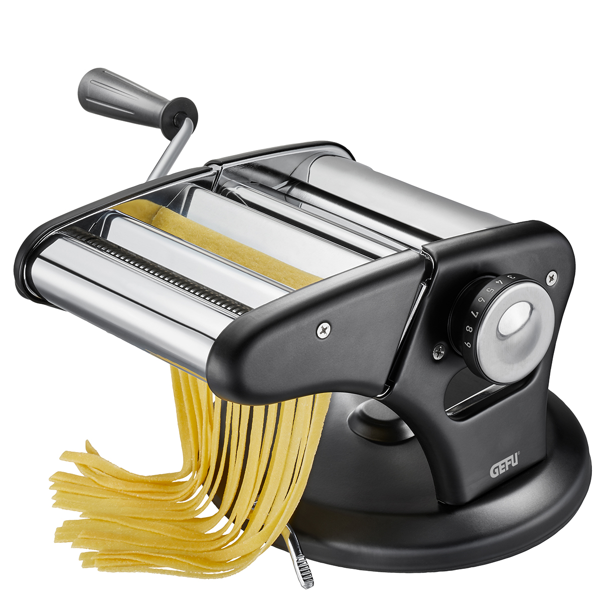 Macchina per pasta in acciaio inossidabile con base nera e fettuccine fresche su sfondo bianco.