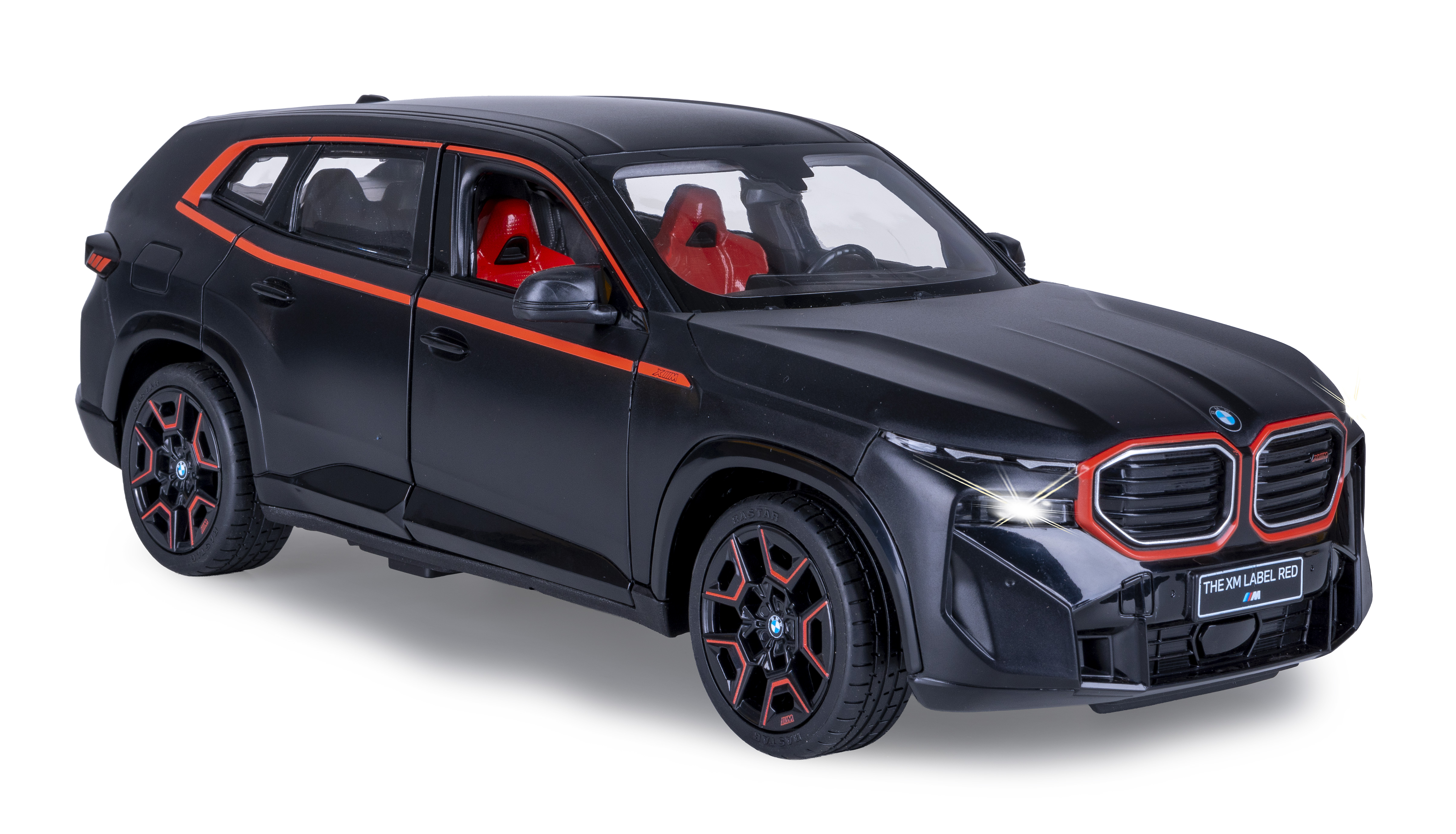 Ein schwarzes Spielzeug-SUV mit roten Akzenten, beleuchteten Scheinwerfern und roten Sitzen, weißer Hintergrund.