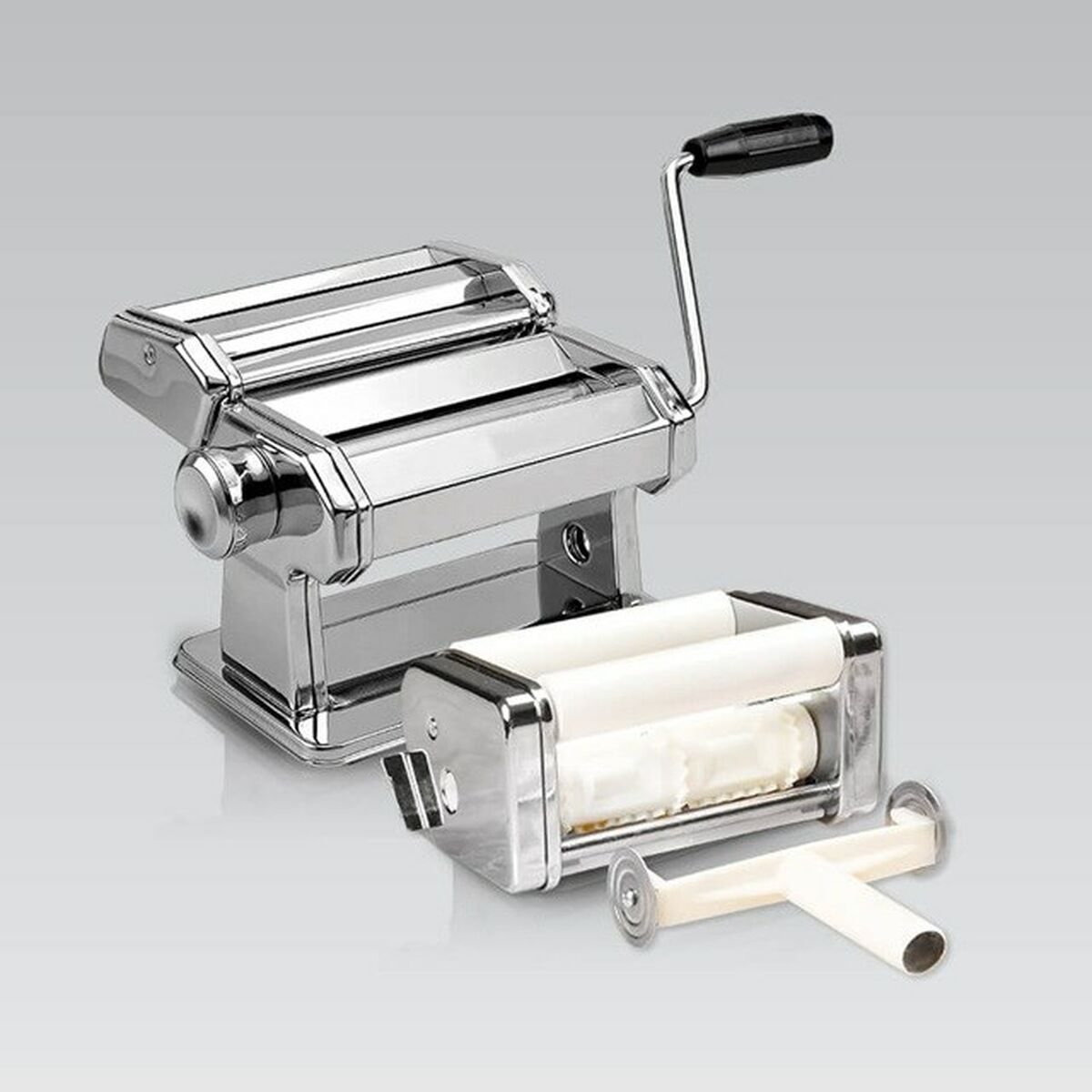 Macchina per pasta in cromo lucido con manovella, un accessorio extra e un piccolo strumento su sfondo grigio.