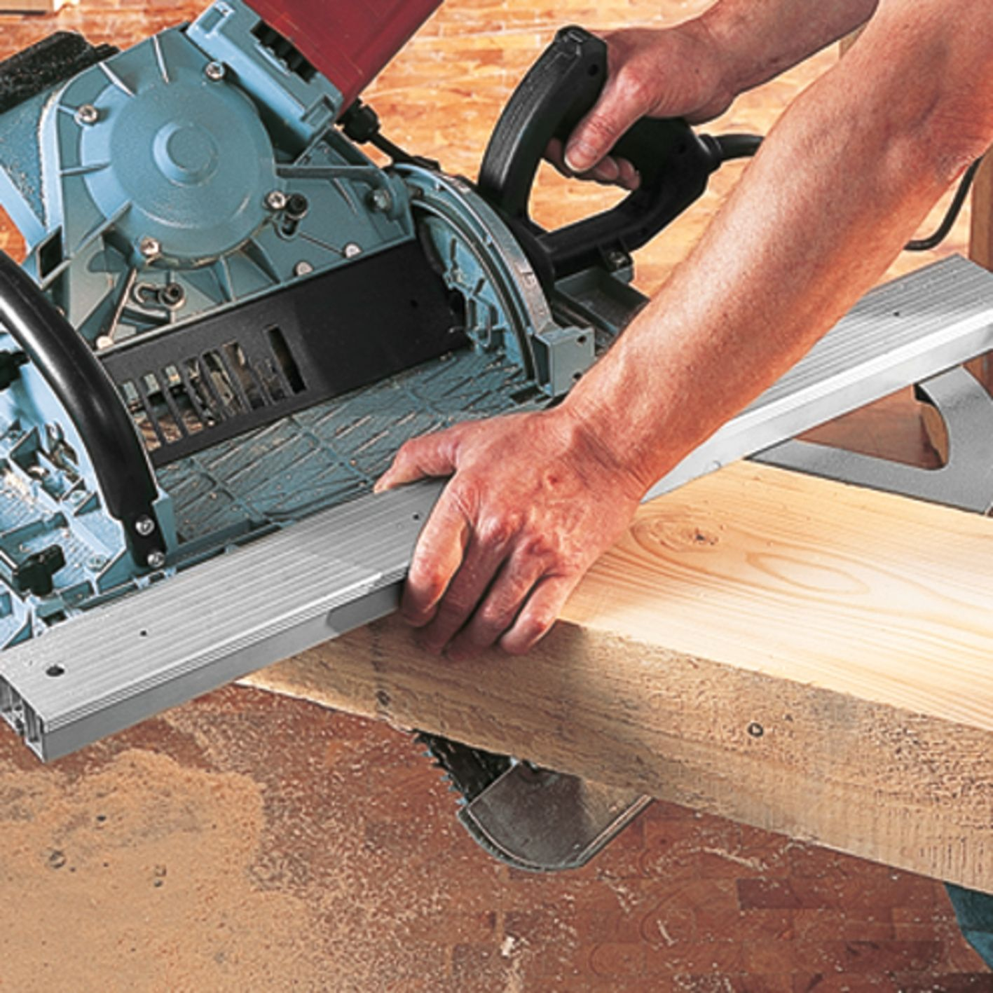 Ein Arbeiter hält ein Holzbrett an einer elektrischen Kreissäge fest.