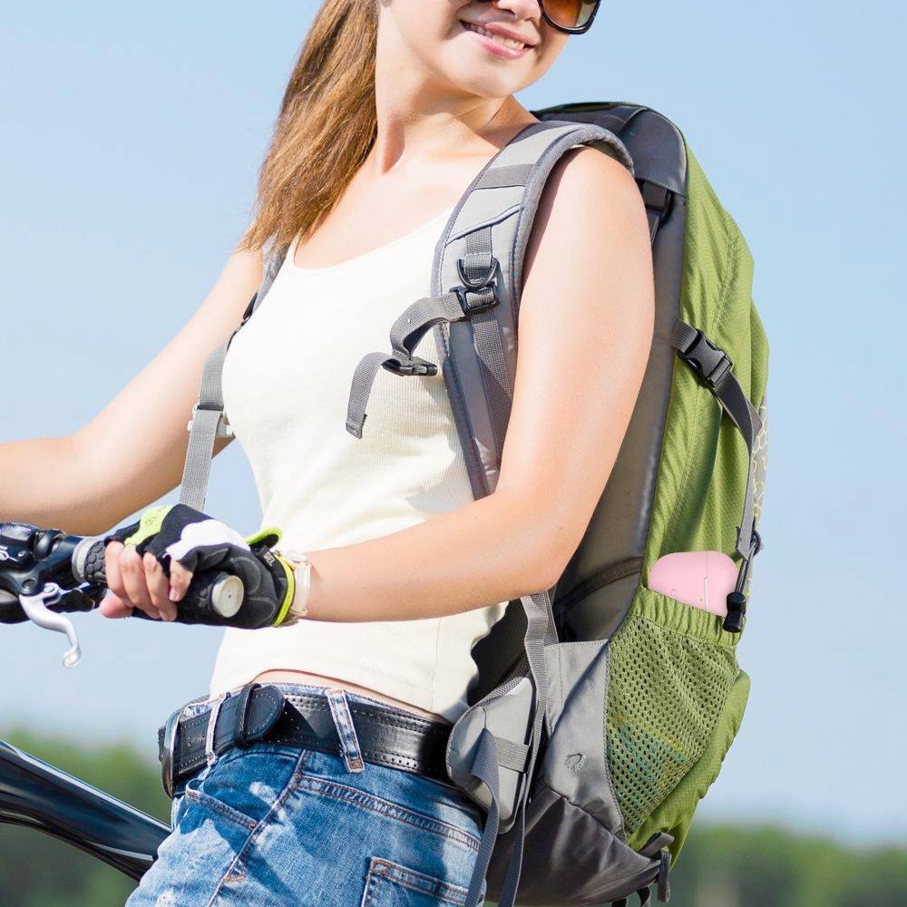 Una donna con canotta bianca e zaino verde va in bicicletta all'aperto sotto un cielo azzurro.