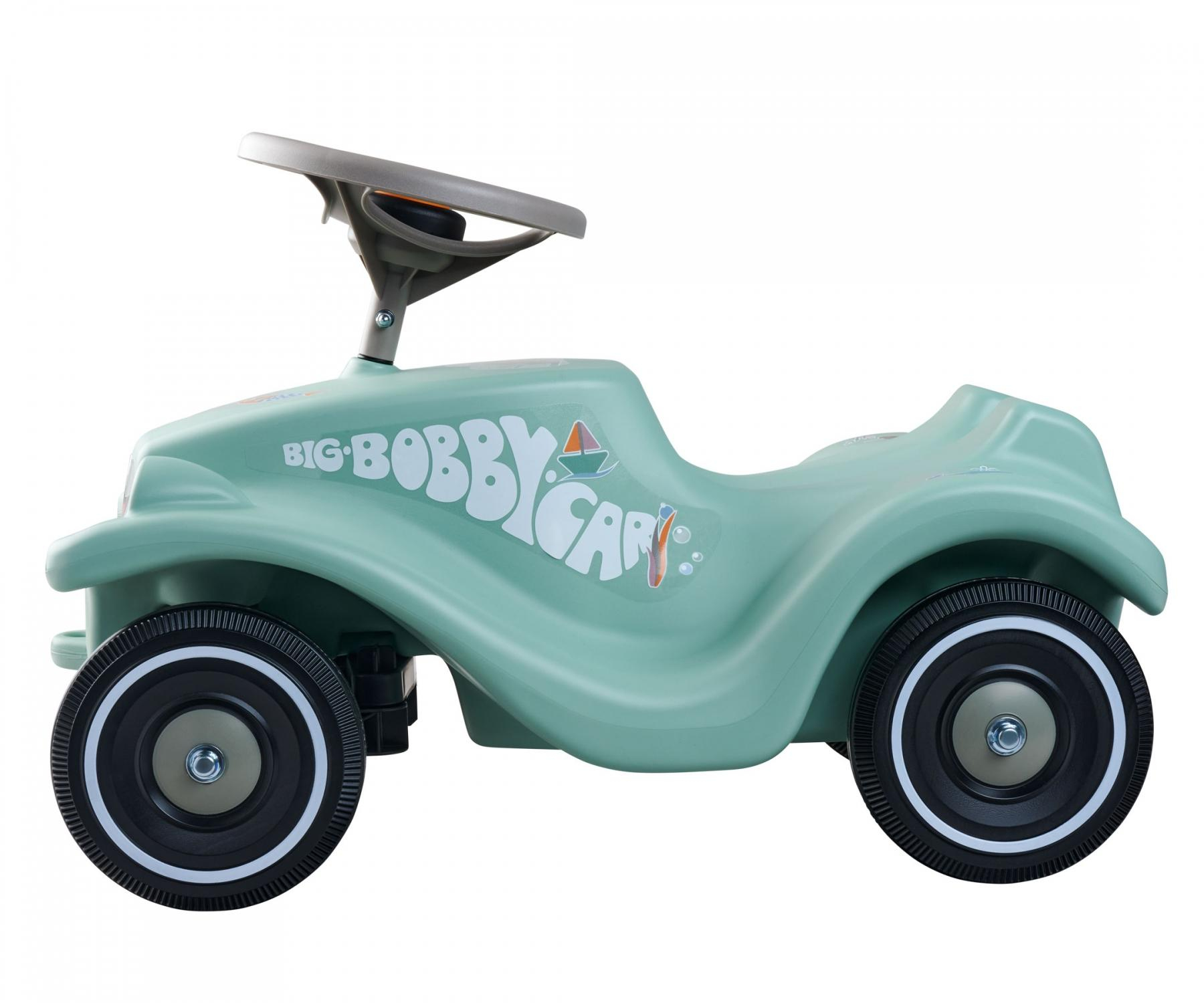 Ein mintgrünes Bobby-Car mit grauem Lenkrad und schwarzen Reifen auf weißem Hintergrund.