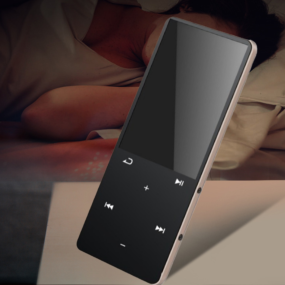 Ein schmaler, schwarzer Musikplayer mit Touch-Steuerung liegt auf einem Tisch, mit einer schlafenden Person im Hintergrund.