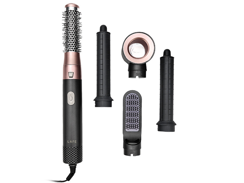 Uno styler per capelli nero con dettagli in oro rosa, accompagnato da quattro accessori.