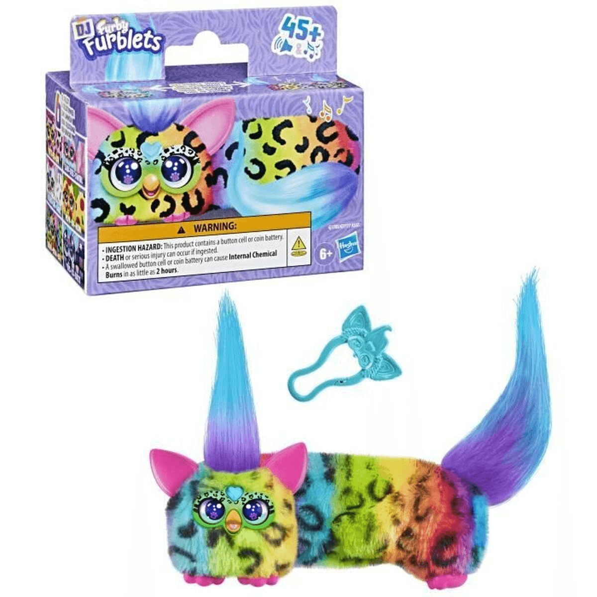 Juguete Furblets colorido con pelaje largo, melena azul y accesorio frente a su caja.