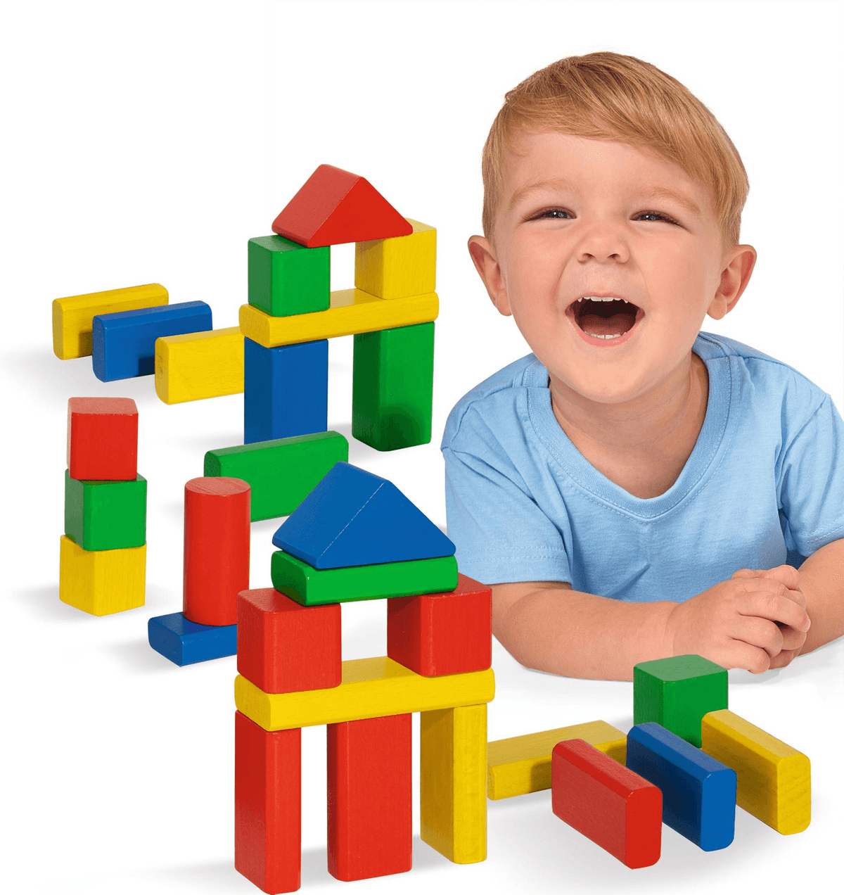 Ein lächelnder Junge in einem blauen Hemd spielt mit bunten Holzbauklötzen, die zu Bauwerken angeordnet sind.