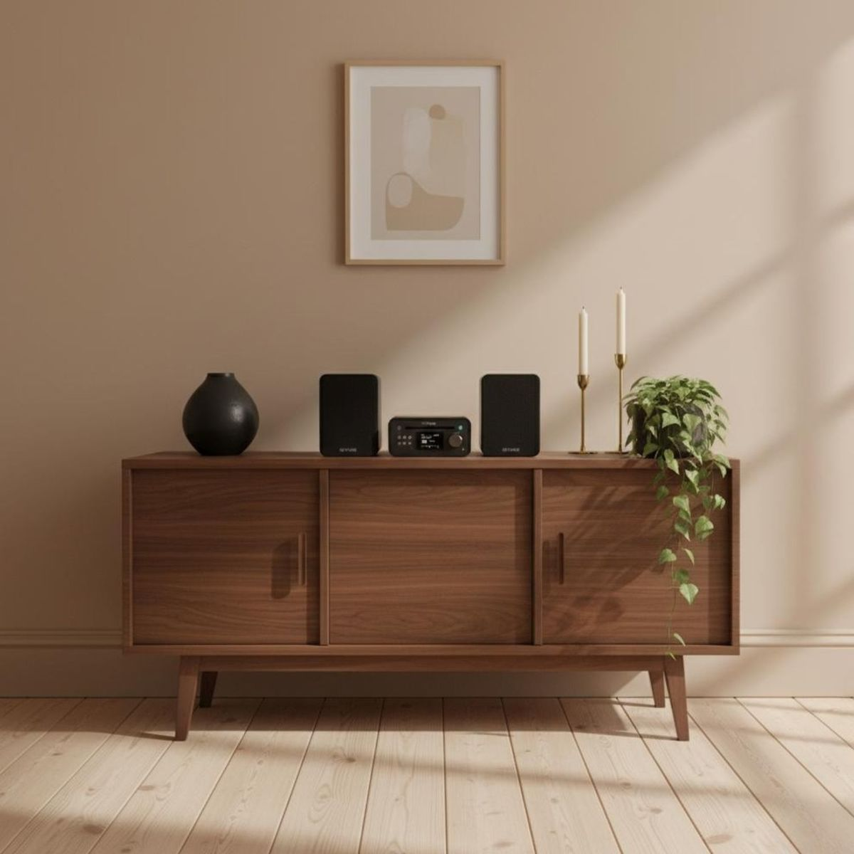 Ein Holzschrank mit Lautsprechern, Stereoanlage, Vase, Kerzen und Topfpflanze vor Wand mit Kunst.