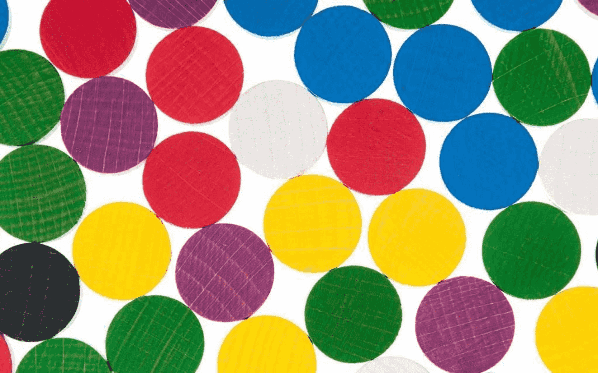 Discos de madera coloridos en rojo, azul, amarillo, verde, morado y blanco sobre fondo blanco.