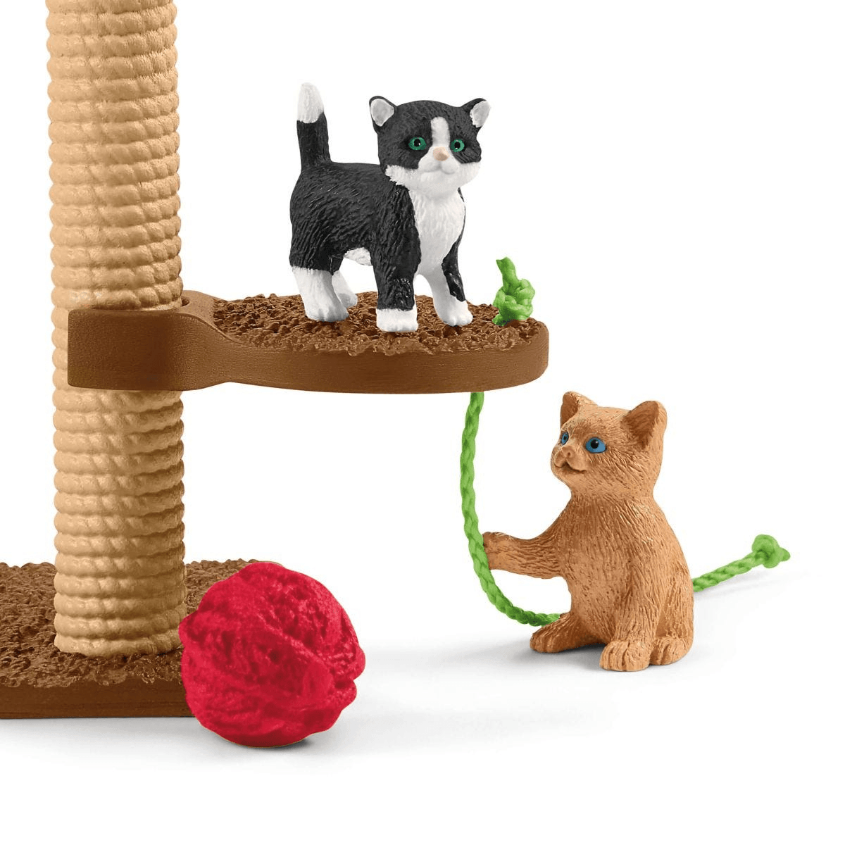 Zwei Katzenfiguren spielen an einem Kratzbaum mit rotem Wollknäuel.