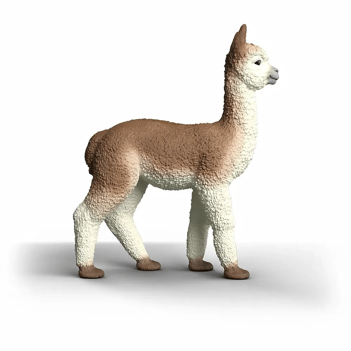 Eine kleine braun-weiße Alpaka-Figur steht auf einem weißen Hintergrund.