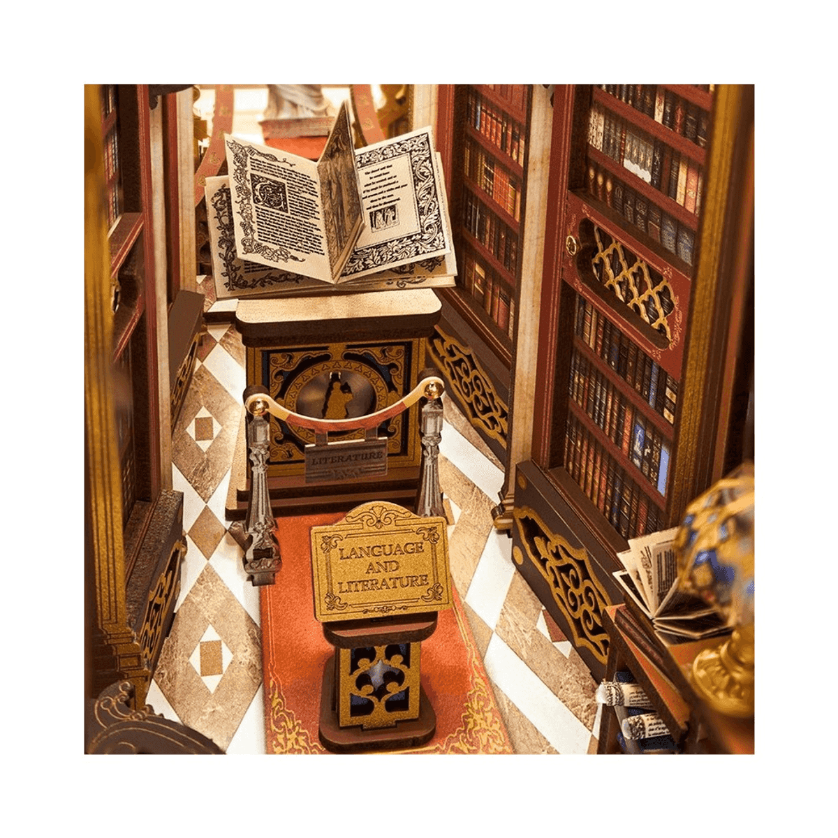 Biblioteca en miniatura con estanterías, libro abierto en un pedestal y un cartel que dice Lengua y Literatura.