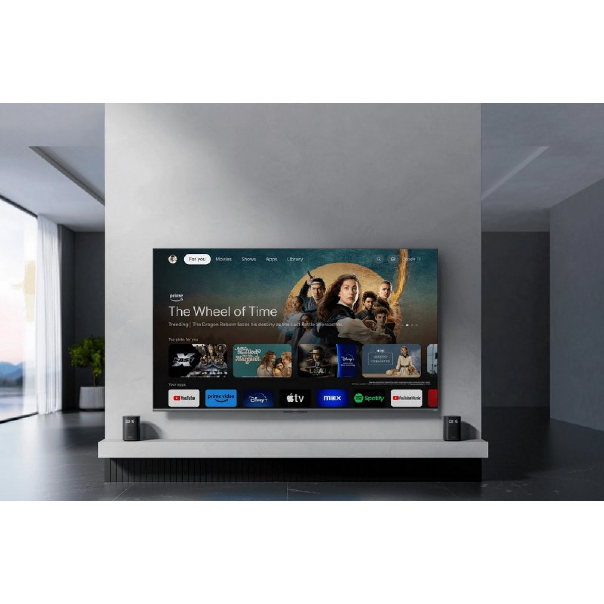Una grande TV su una parete grigia in un soggiorno moderno mostra il menu di un'app.