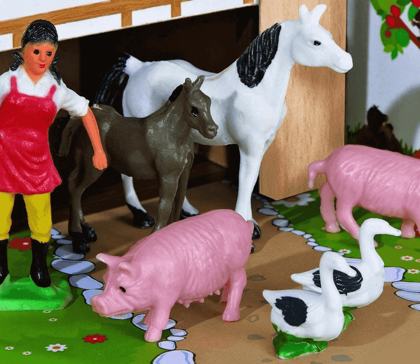 Escena de granja de juguete con agricultora, caballos, cerdos y patos.
