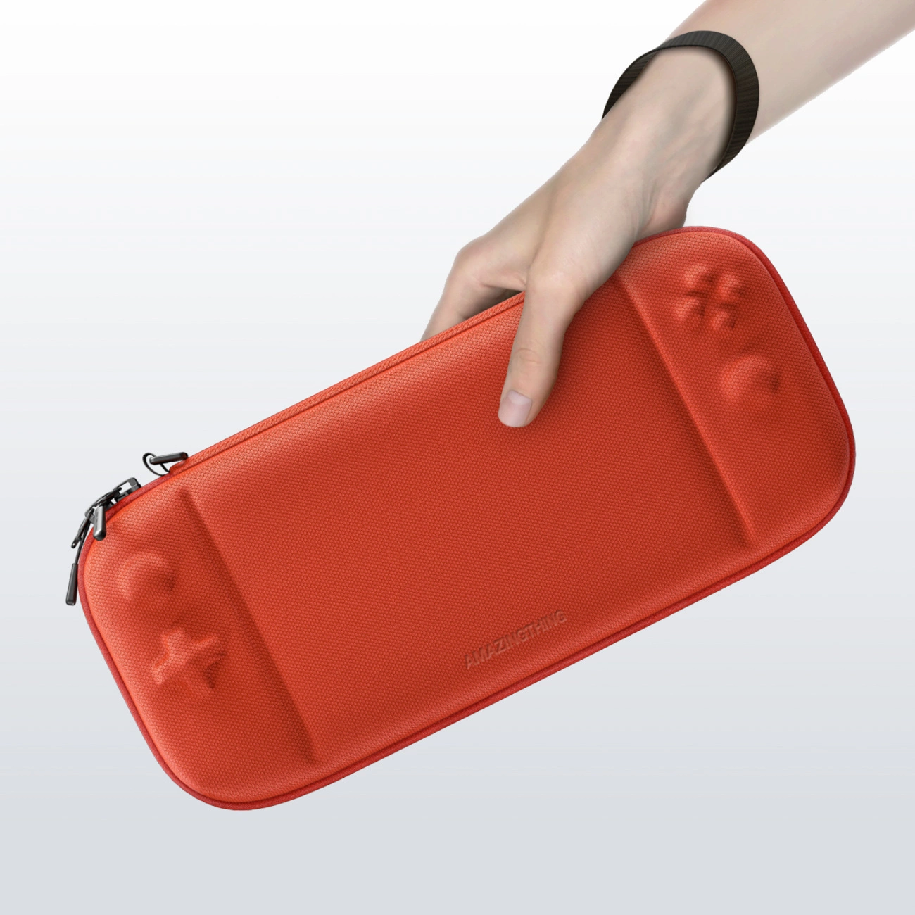 Una mano tiene una custodia per console di gioco rossa e rettangolare su sfondo bianco.