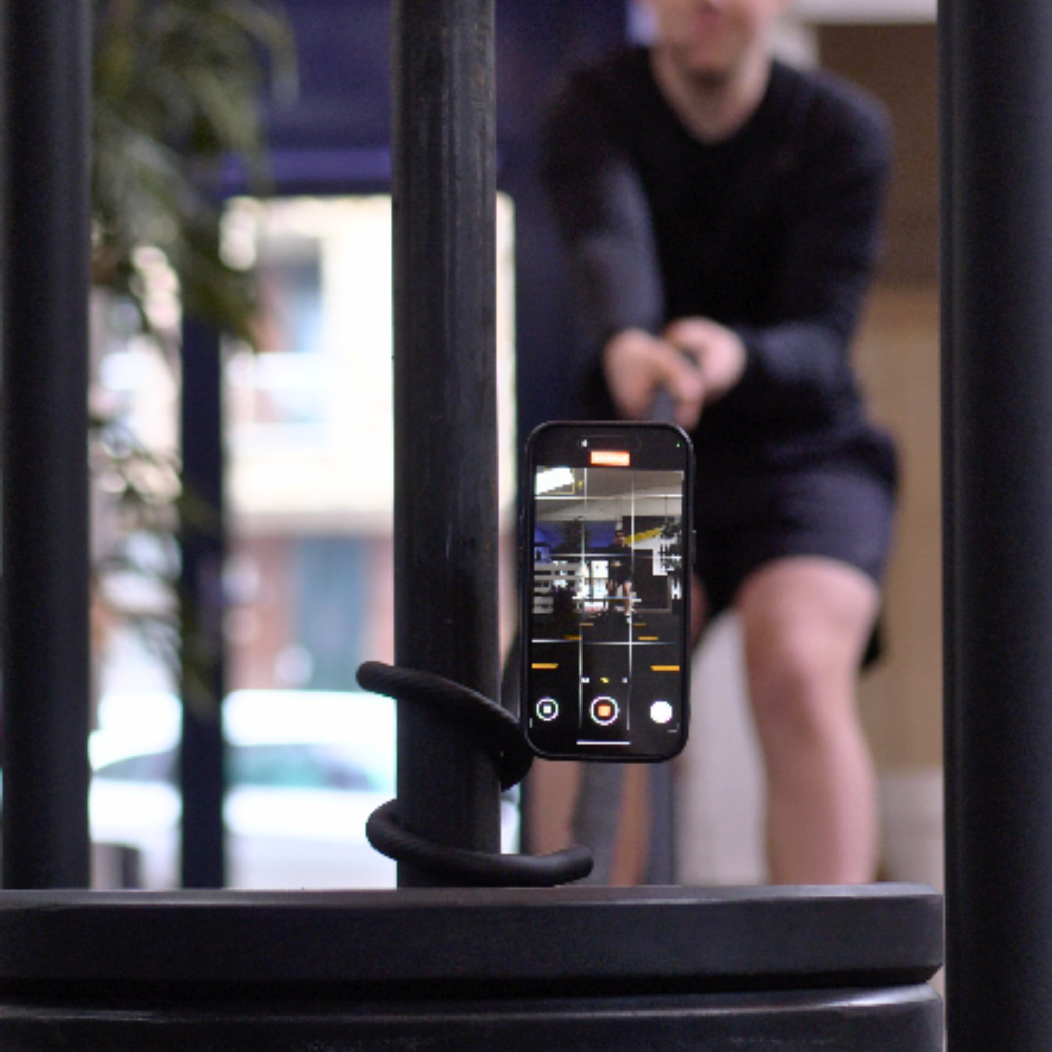Een smartphone op een flexibel statief filmt een sportende man.