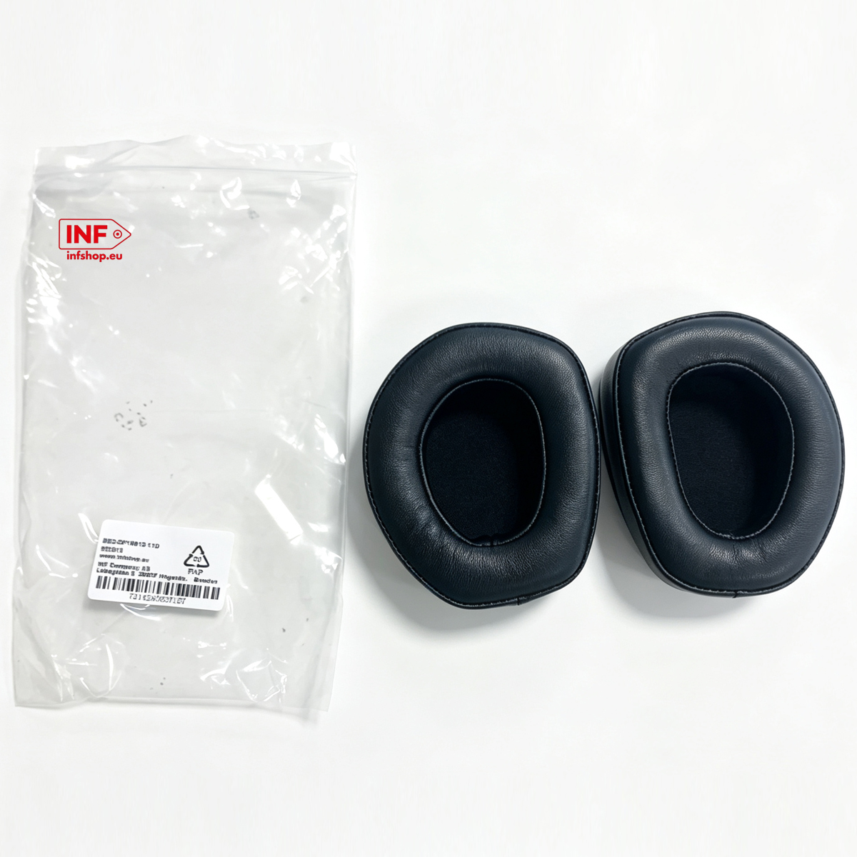 Due cuscinetti auricolari neri e un sacchetto di plastica trasparente con etichetta.