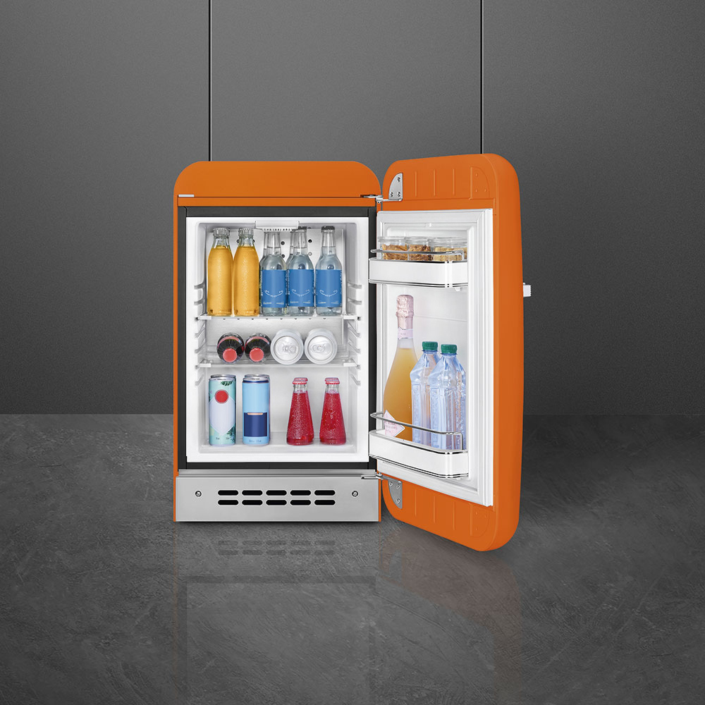 Un mininevera abierta y de color naranja brillante está llena de botellas y latas de bebidas.