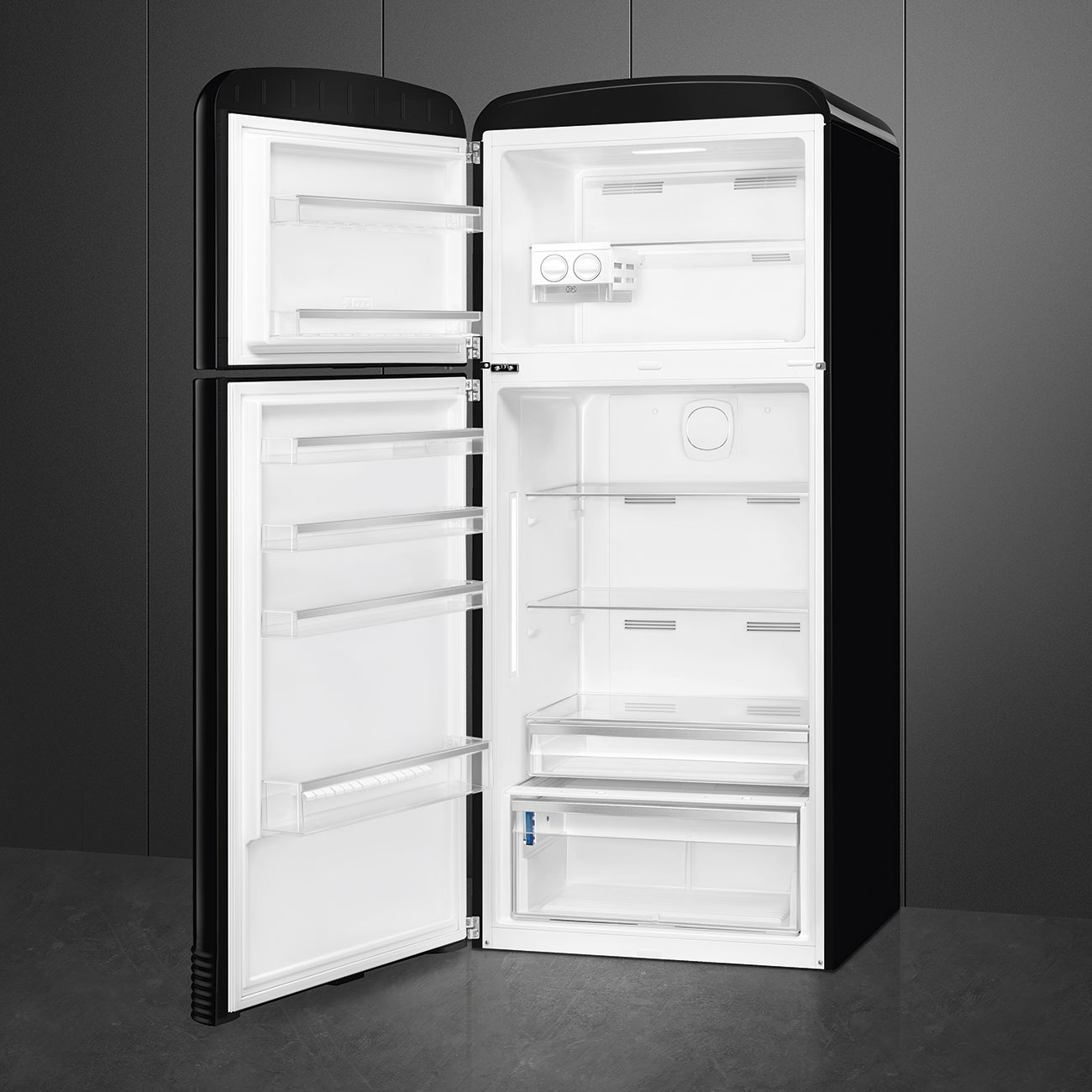 Un refrigerador retro negro abierto con estantes de vidrio vacíos, compartimentos en la puerta y cajones.