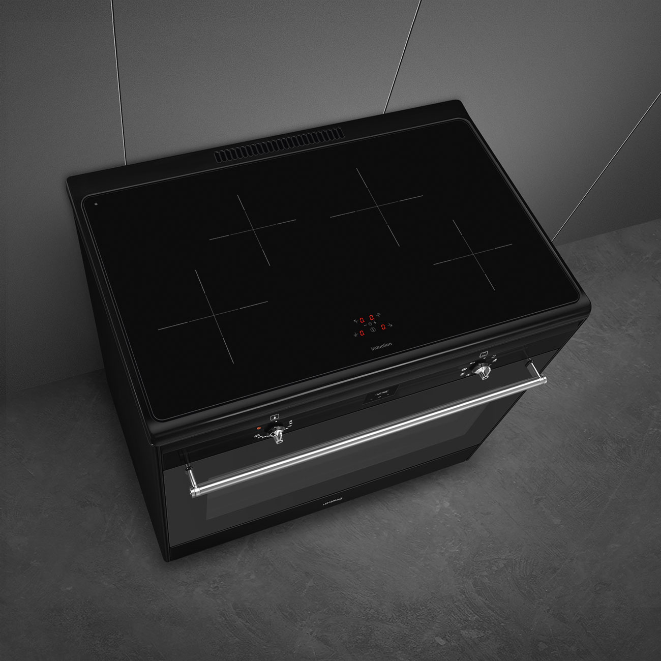 Una cucina a induzione nera con quattro zone cottura e maniglie argentate in una cucina moderna.