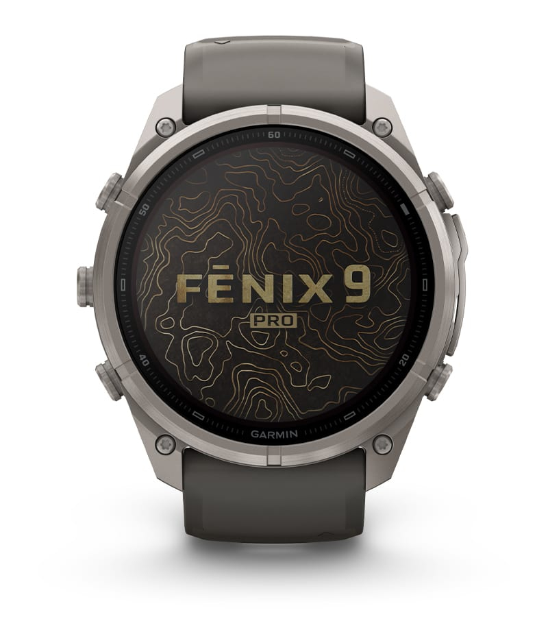 Un reloj inteligente Garmin Fenix 9 Pro gris con un patrón de mapa topográfico en la esfera.
