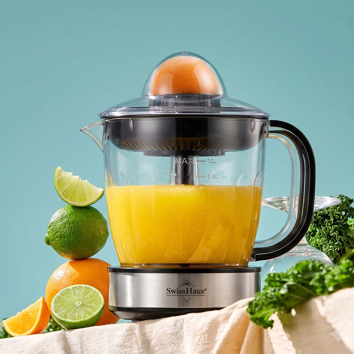 Eine elektrische Saftpresse auf einer Tischplatte, befüllt mit Orangensaft, umgeben von Zitrusfrüchten und grünem Blattgemüse.