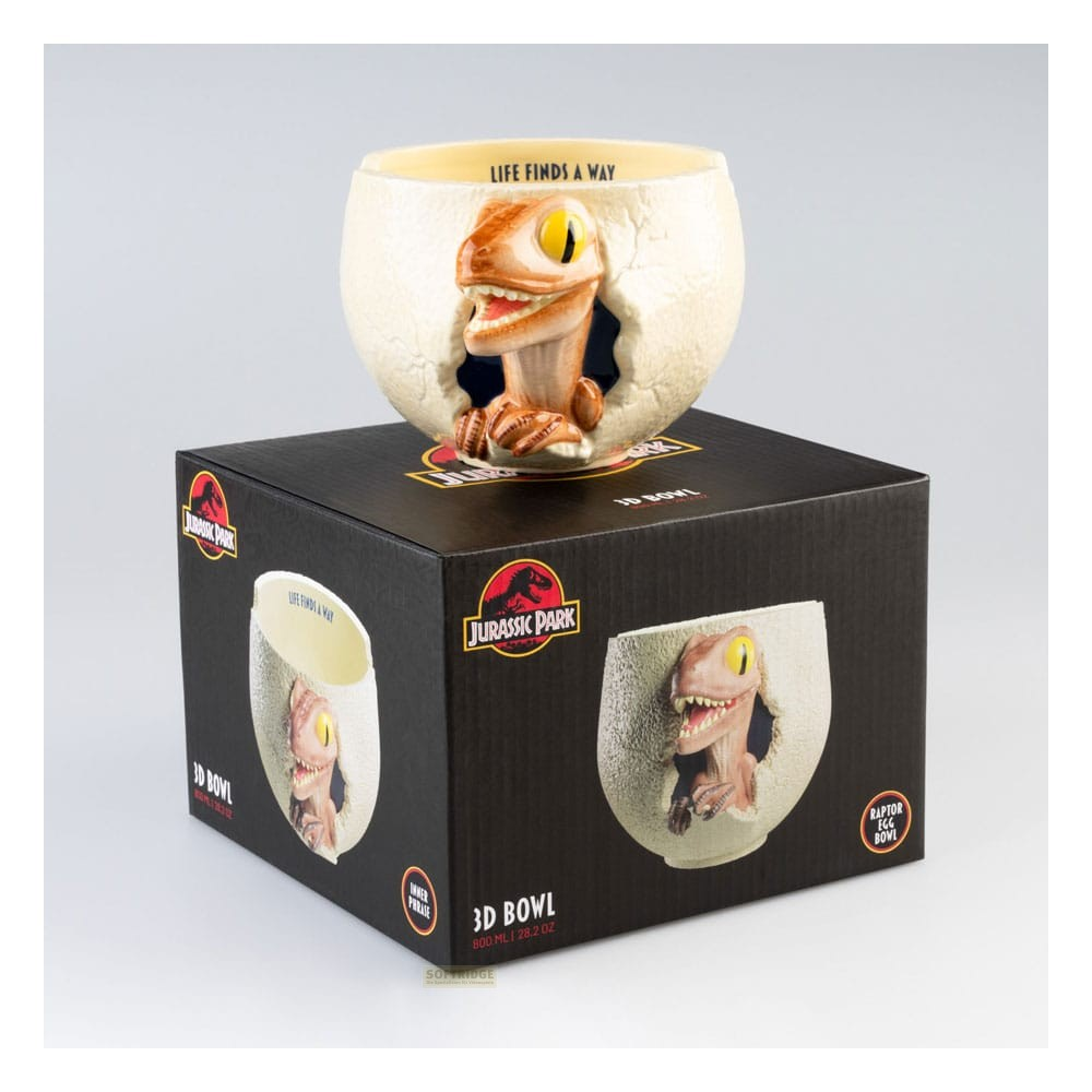Un bol blanco con forma de huevo de raptor de Jurassic Park sobre su caja negra correspondiente.