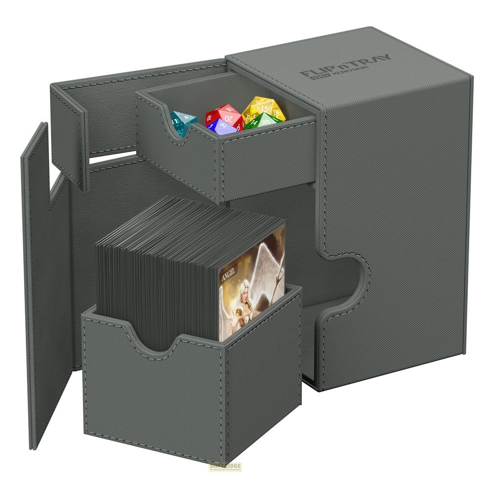 Une boîte de jeu grise avec un plateau ouvert rempli de dés et un grand jeu de cartes à l'avant.