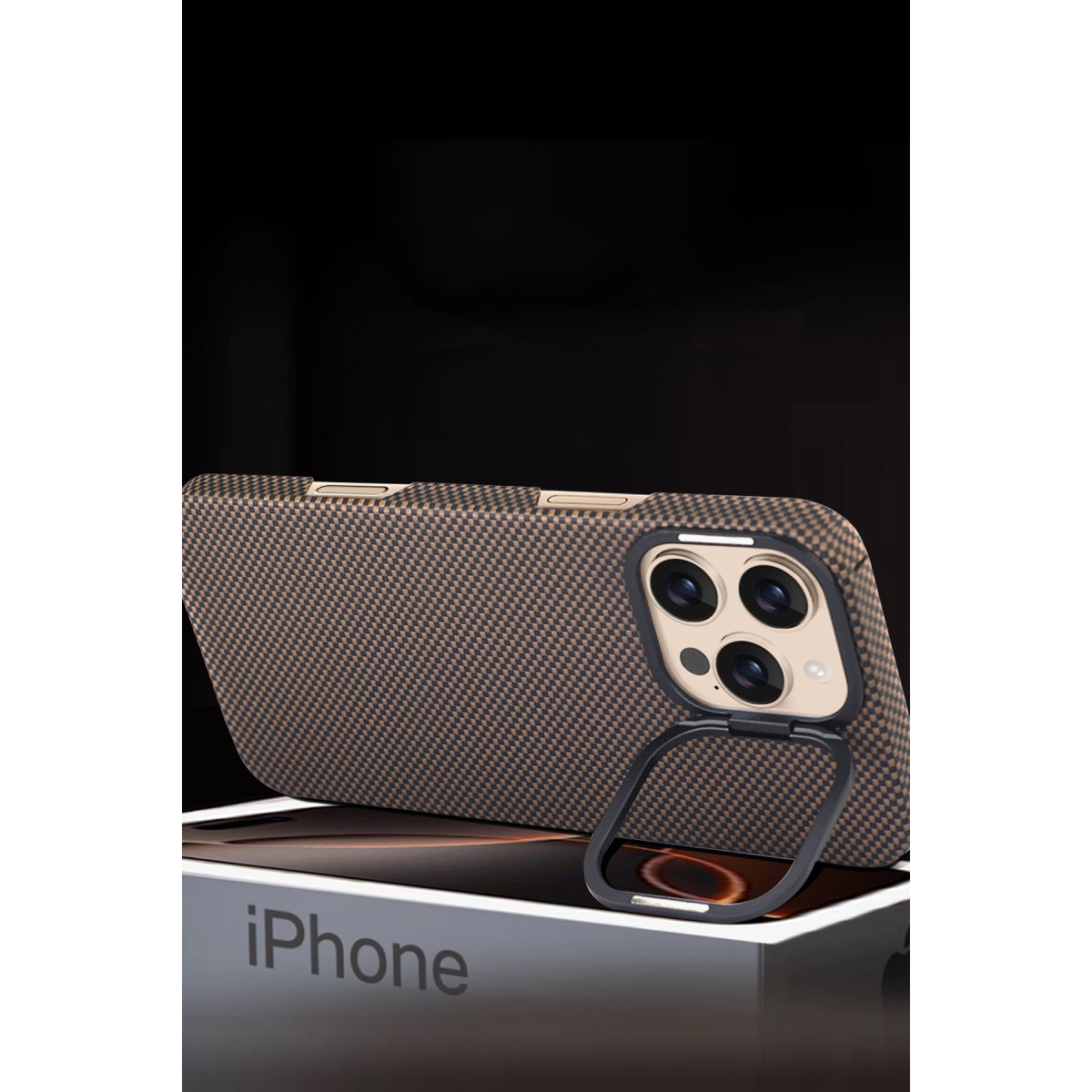 Karbon fiber kılıflı ve ayaklı bir iPhone, siyah arka plan önünde bir iPhone kutusu üzerinde duruyor.