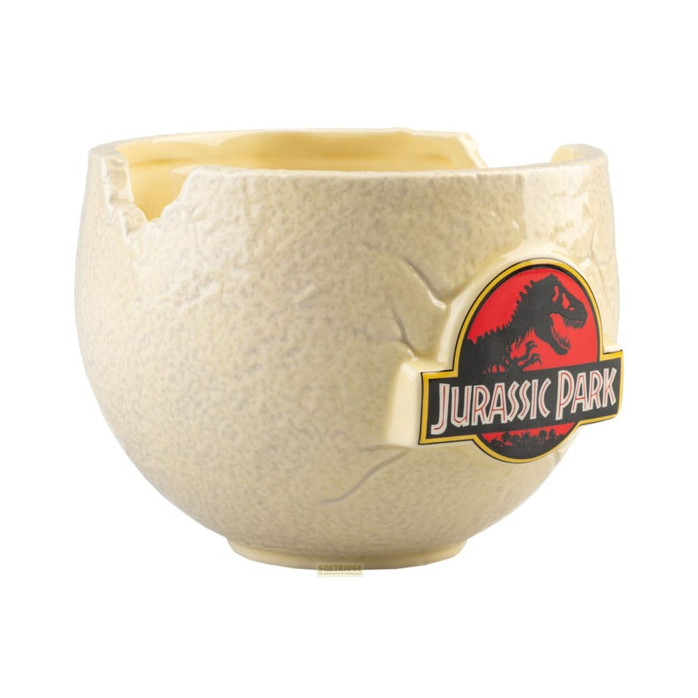 Una taza de color crema con forma de huevo de dinosaurio agrietado con el logotipo de Jurassic Park en el frente.