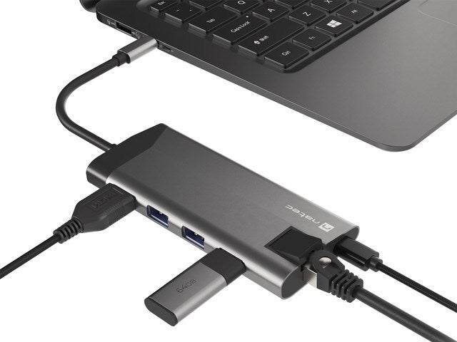 Hub USB-C grigio collegato a un computer portatile con vari cavi e una chiavetta USB.