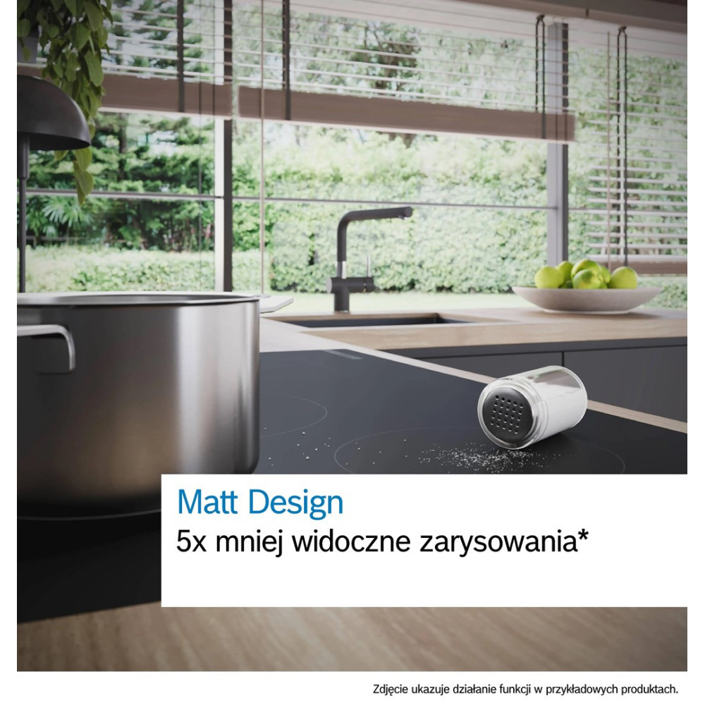 Cocina moderna con una olla en una placa de inducción negra y un salero.
