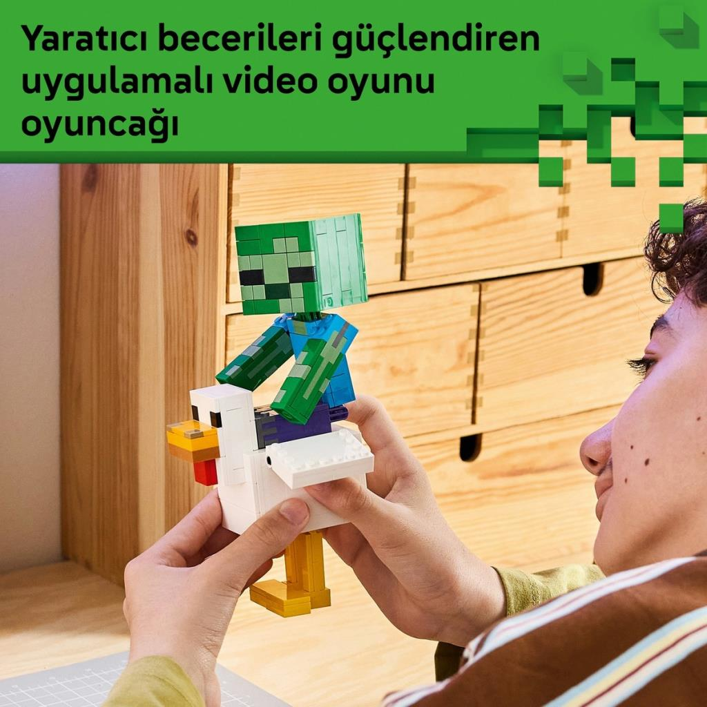 Bir çocuk ahşap çekmecenin önünde tavuğa binen bir LEGO Minecraft zombi oyuncağı tutuyor.
