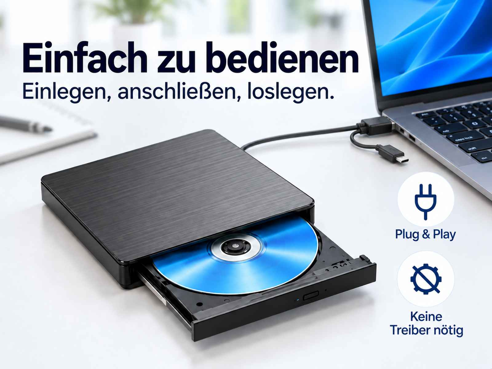 Externes CD/DVD-Laufwerk verbunden mit einem Laptop auf einem Tisch mit Text auf Deutsch.
