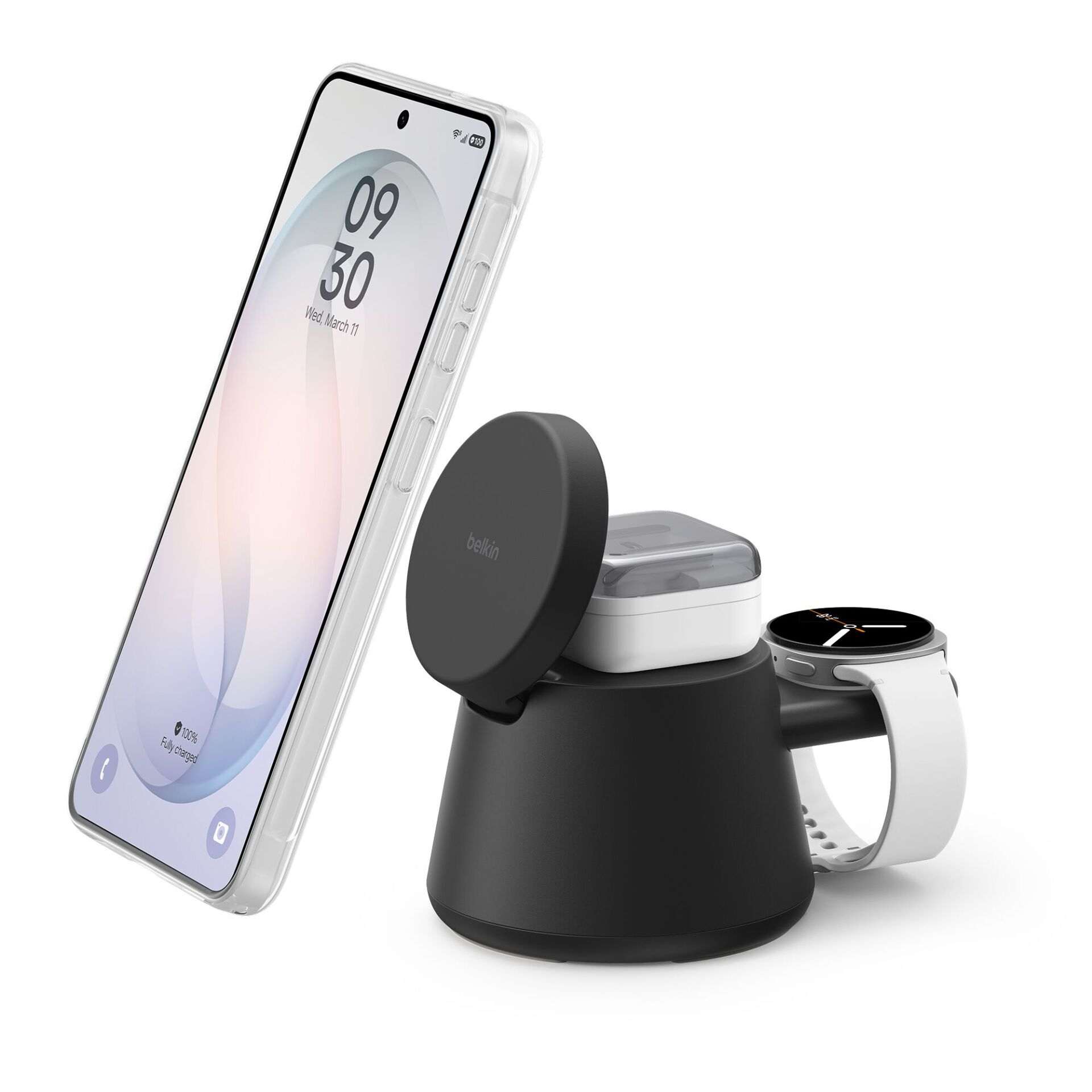 Stazione di ricarica Belkin nera 3 in 1 con smartphone, auricolari e smartwatch su sfondo bianco.