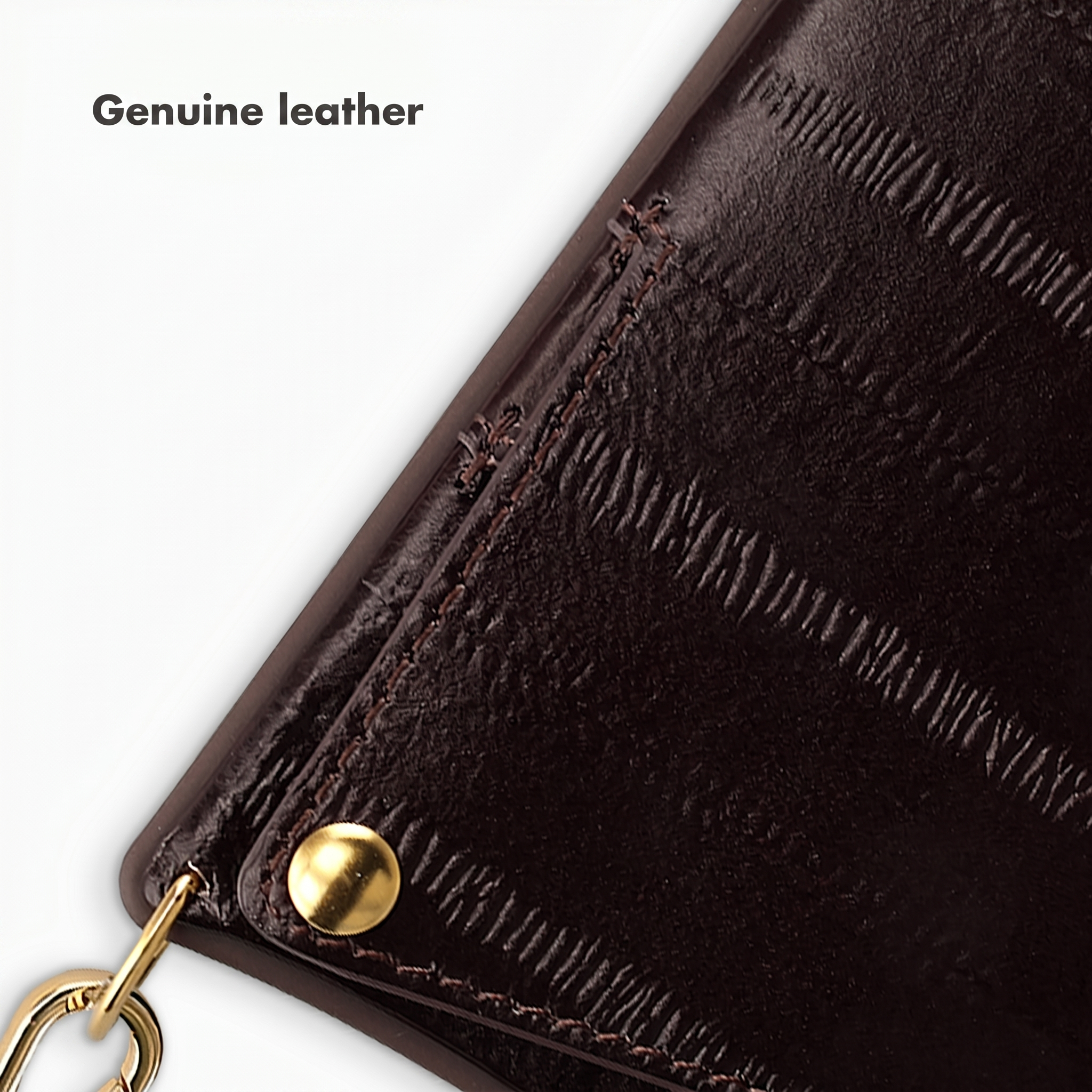 Close-up van donkerbruin getextureerd echt leer met een gouden klinknagel en ketting.