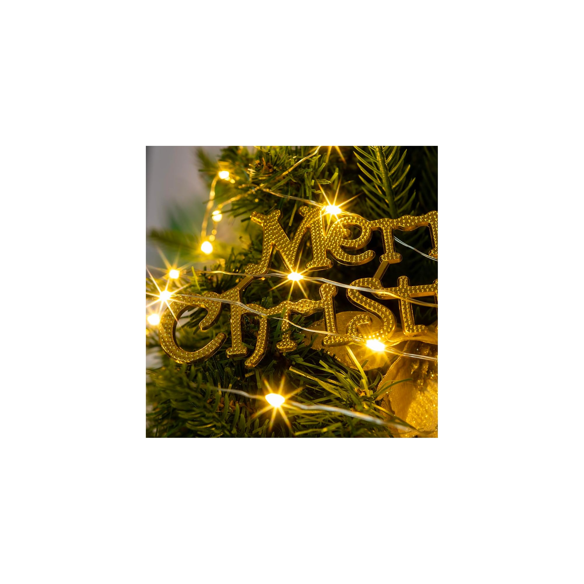 Goldener Merry Christmas Schriftzug auf einem Tannenbaum mit leuchtenden Lichterketten.
