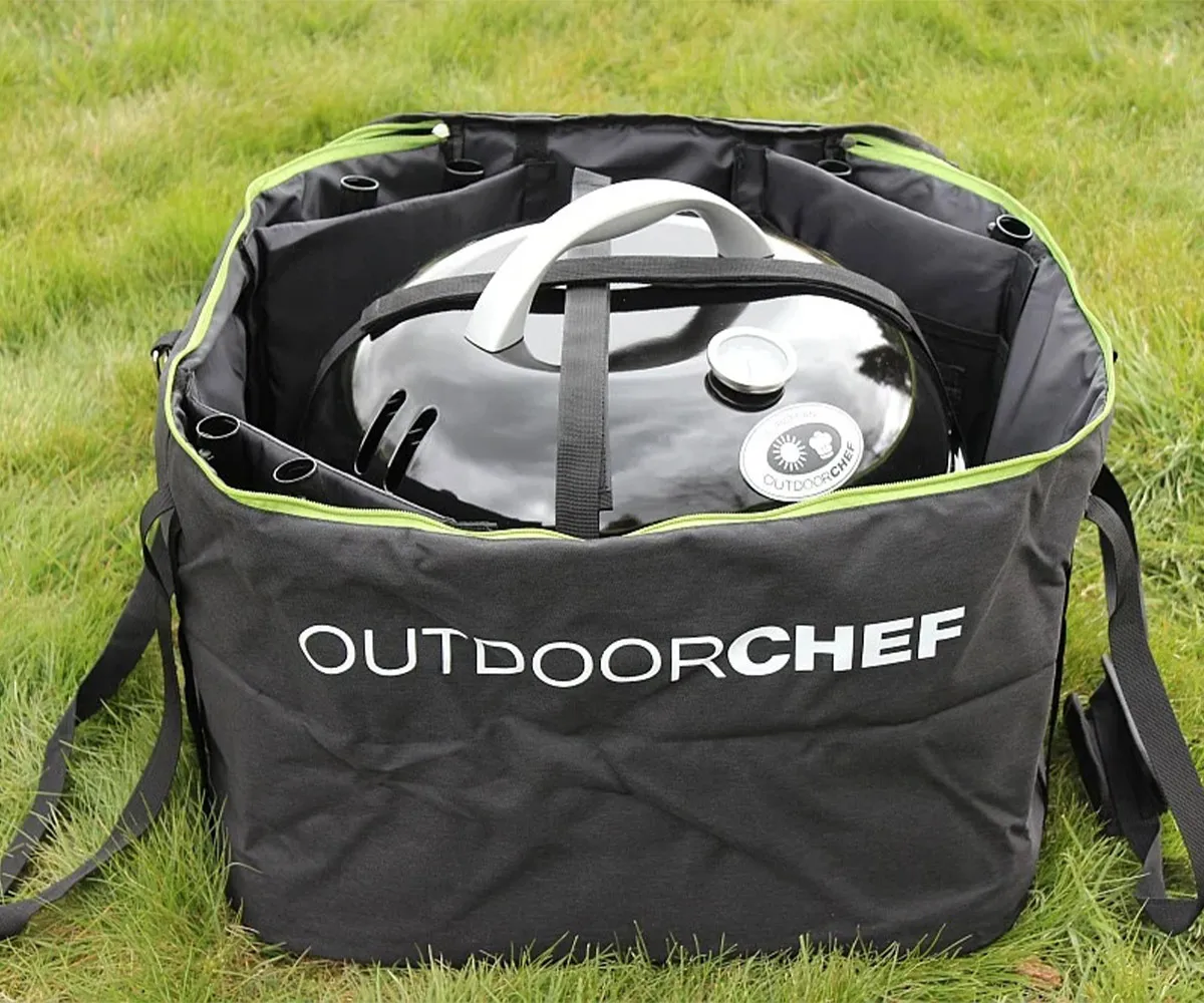 Çim üzerinde siyah taşıma çantasında paketlenmiş bir Outdoorchef mangal.