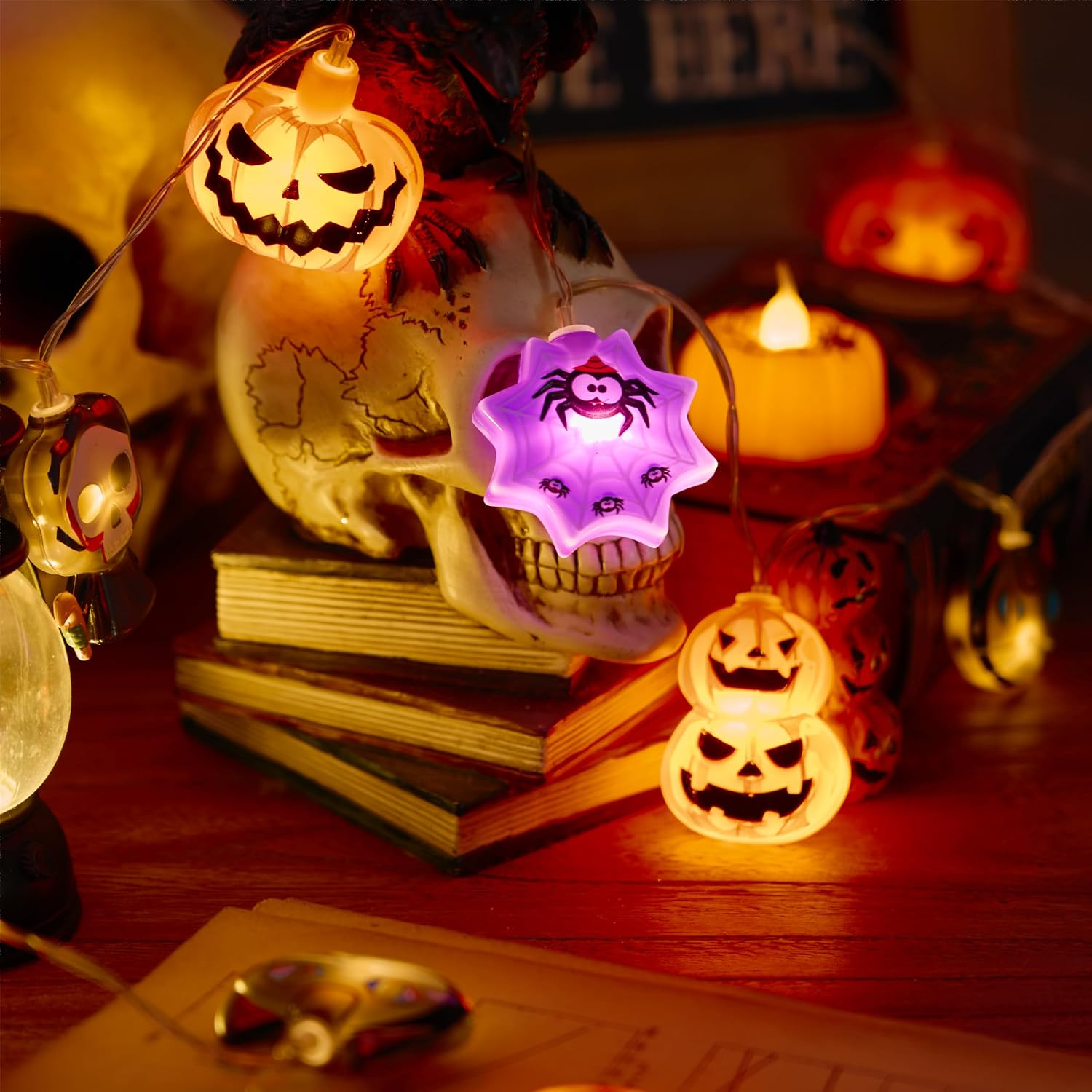 Halloween-Lichterketten leuchten warm um einen Totenkopf auf gestapelten Büchern und Kerzen.
