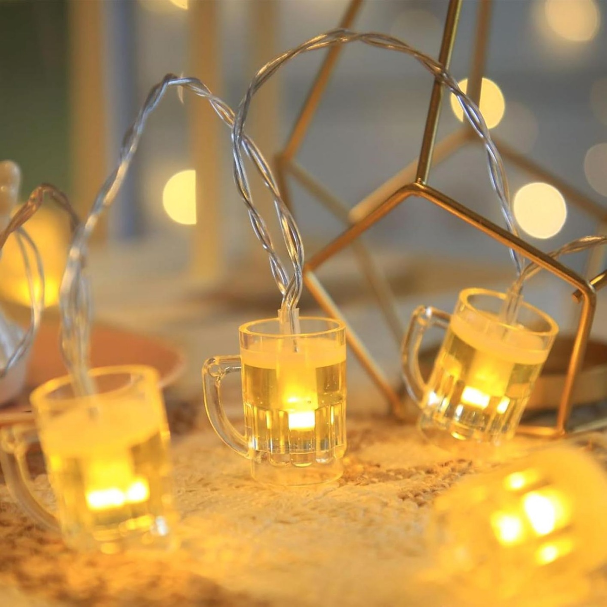 Lichterkette mit kleinen beleuchteten Bierkrug-Aufhängungen und weichem, goldenem Hintergrundlicht.