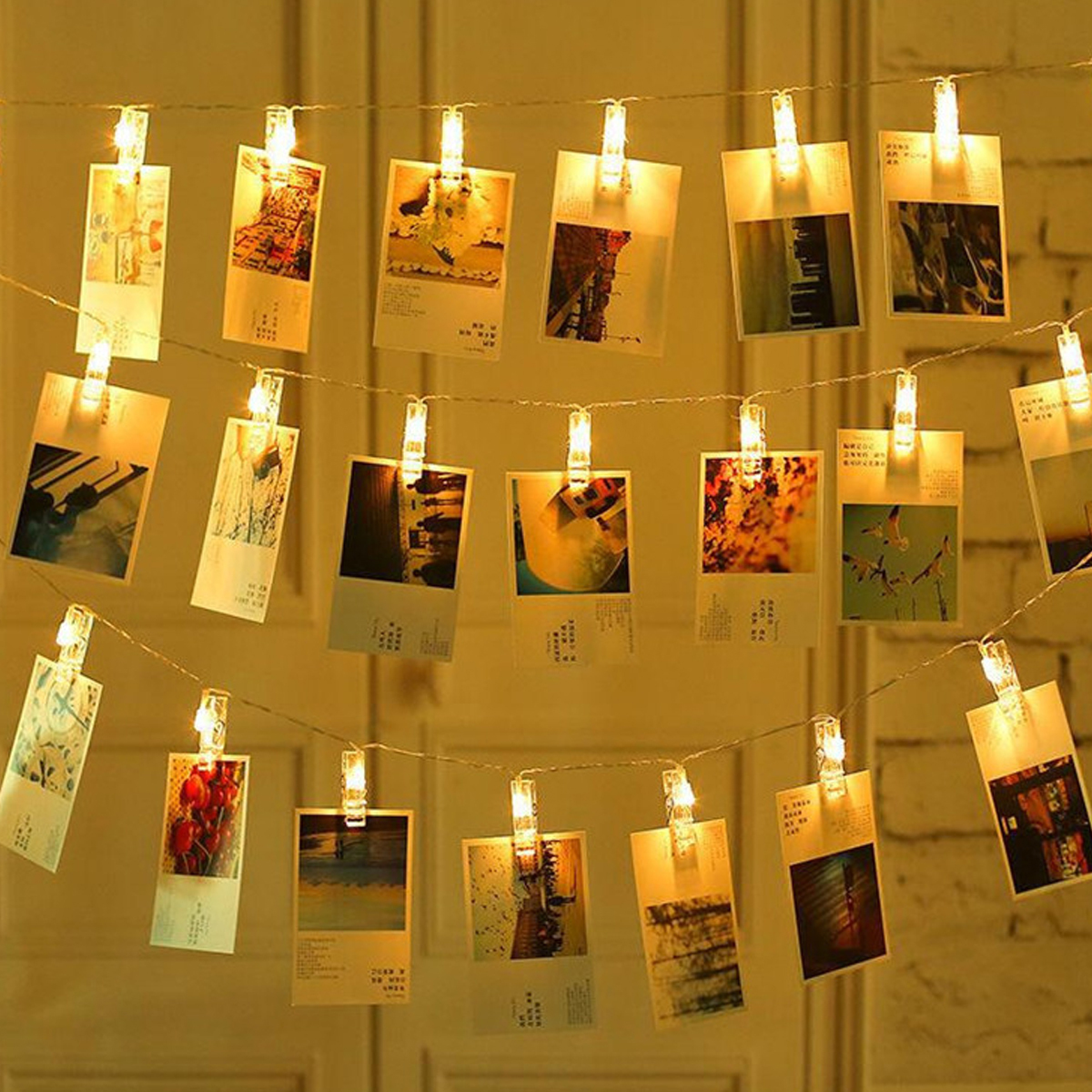 LED-Lichterkette mit kleinen Klammern, die Fotos an drei Strängen beleuchten.