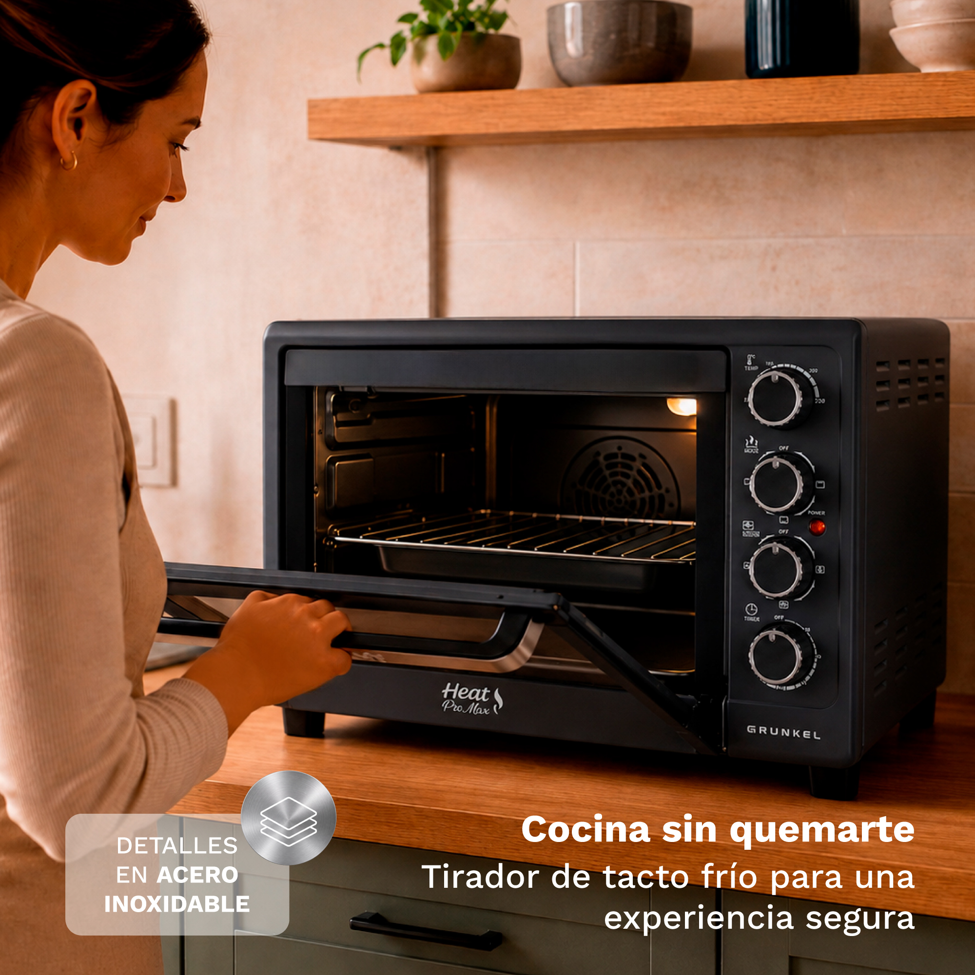 Una mujer abre un mini horno negro con tirador de tacto frío en una encimera de madera.