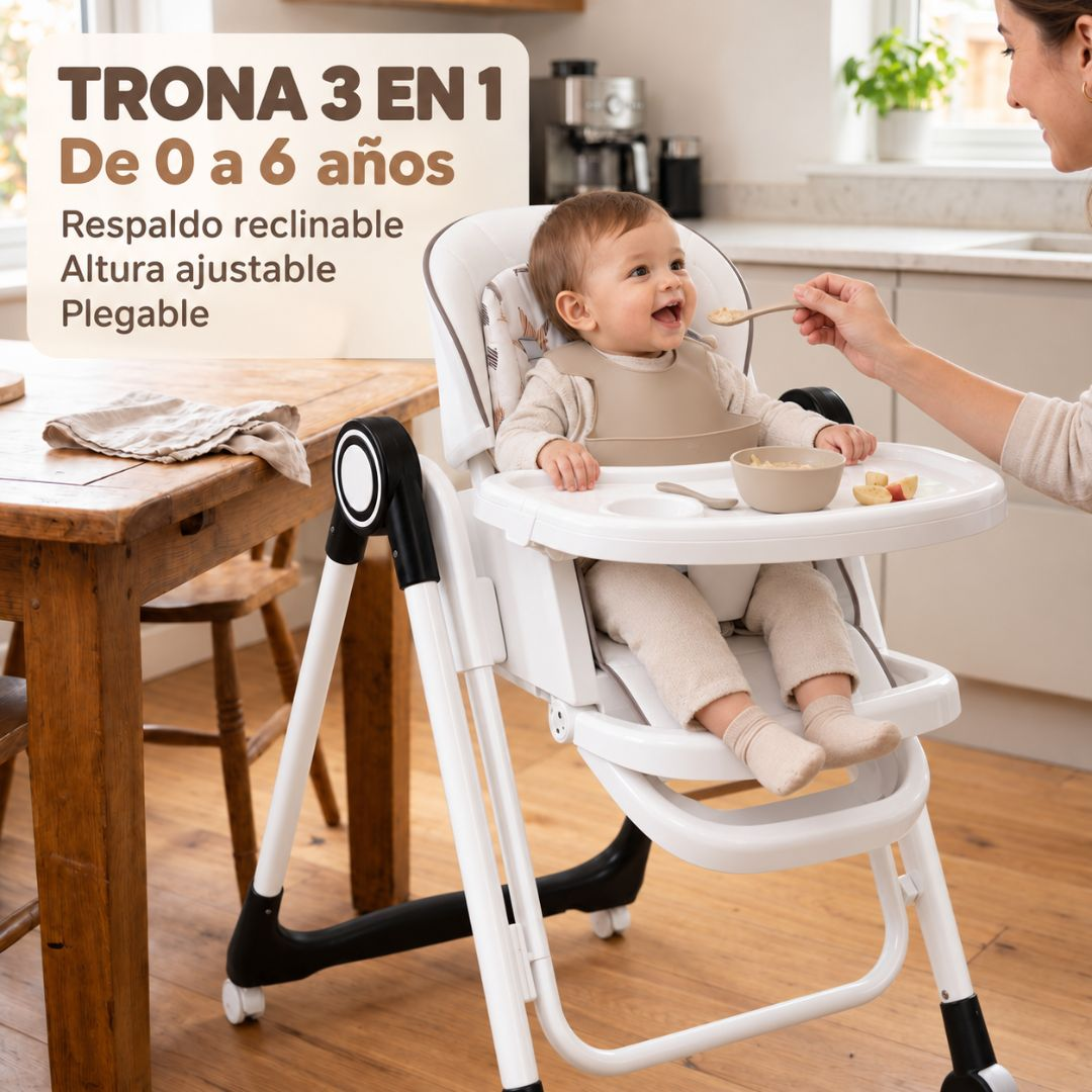 Un bebé está sentado en una trona blanca mientras una persona le da de comer. De fondo hay una cocina.