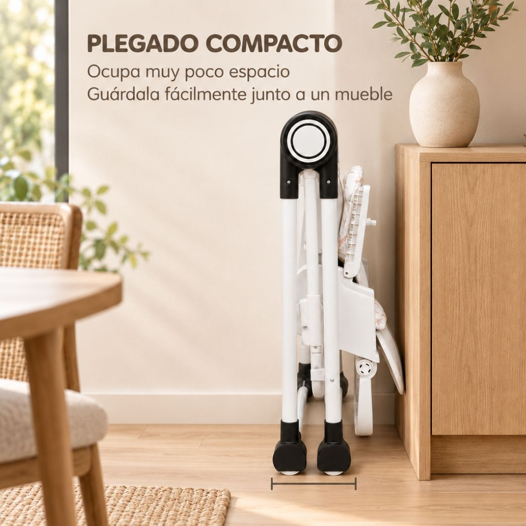 Una trona blanca plegada se encuentra junto a un mueble de madera en una habitación luminosa.