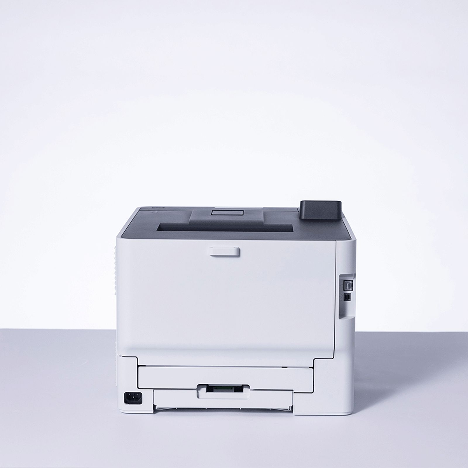 Ein weißer Drucker steht auf einer hellen Oberfläche vor einem weißen Hintergrund.